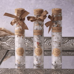 Velarte bath salts in a clear glass tube, containing aromatic white and pink bath salts for relaxing bath experience.