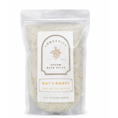 Green bath salt container labeled Longevity Oat & Honey Epsom Bath Salt by AW GIFTS, featuring natural ingredients and a calming spa design.