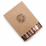 Set of seven AW GIFTS bath salts in clear vials, ideal for gifting or relaxing spa use.