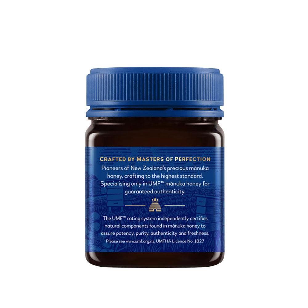 Herbalistas Haddrells Manuka Honey UMF5+ MGO83+ in 250g jar, showcasing the golden, thick honey with a honey dipper.