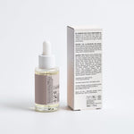 Bottle of SELFNAMED Rosemary Hair & Scalp Strengthening Oil with rosemary sprigs and a wooden dropper in natural lighting.