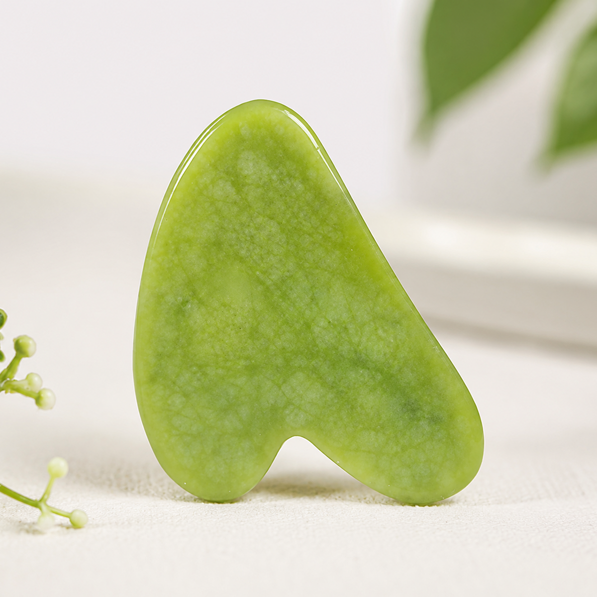 Emerald Xiuyan Gua Sha stone by TEMU, handcrafted natural facial and body massage tool with smooth, polished surface for skincare.