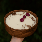 Soy wax candle in a wooden bowl by Velarte, showing a warm, rustic candle with a natural wooden container.