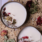 Soy wax candle in a coconut bowl from Velarte, with a lit wick and natural coconut shell exterior.