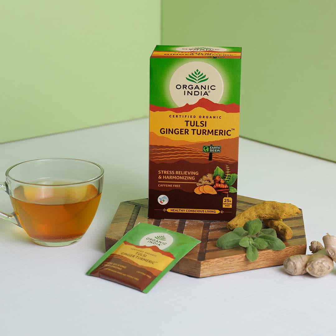 Organic India Tulsi Turmeric Ginger herbal tea in a box, featuring fresh ginger and turmeric roots on the packaging.