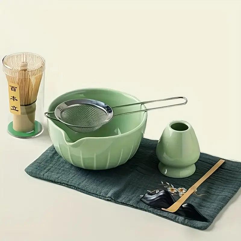 Set of seven matcha tea ceremony accessories in green, including bowls, whisks, and utensils, for authentic Japanese matcha preparation.