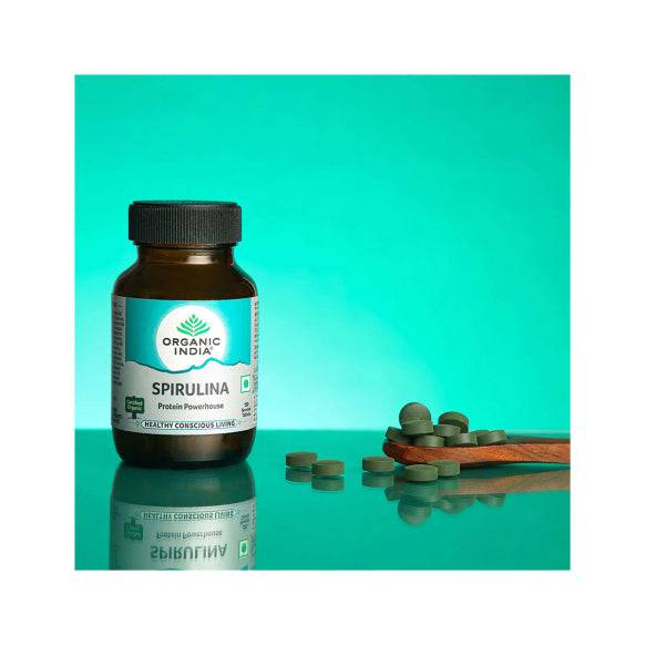 Organic India BIO Spirulina veggie tablets in a bottle, showing green tablets and label with product details.